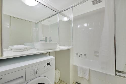 悉尼City apartment at College St的白色的浴室设有水槽和洗衣机。
