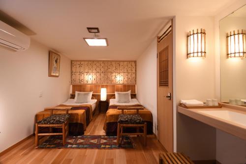 京都晴鸭楼日式旅馆的酒店客房设有两张床和盥洗盆