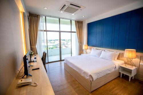 帕府普莱纳卡拉酒店的一间卧室配有一张床和一张书桌及电视