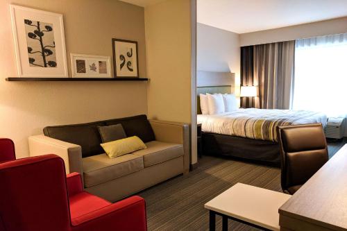 斯莱德尔Comfort Inn & Suites的酒店客房配有床、沙发和椅子