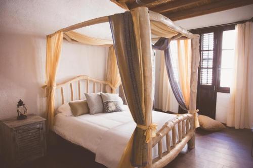 北尼科西亚The Iskemleci Guest House的一间卧室配有带窗帘的天蓬床