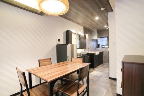 东京Villa Ikebukuro的厨房以及带木桌和椅子的用餐室。