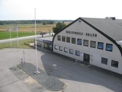 HerlufmagleHerlufmagle Hallen的一座白色的大建筑,旁边有一个标志