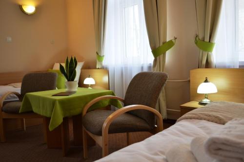 伊诺弗罗茨瓦夫Willa Ostoja的酒店客房带绿色的桌子和椅子
