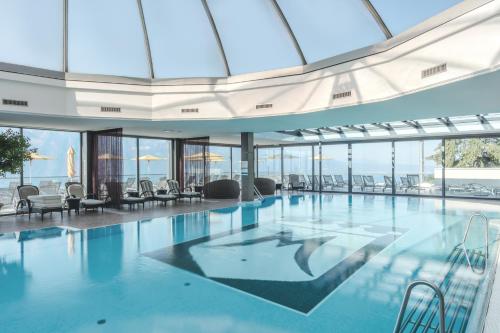 沃韦米兰朵度假酒店及Spa的一个带椅子和窗户的大型游泳池