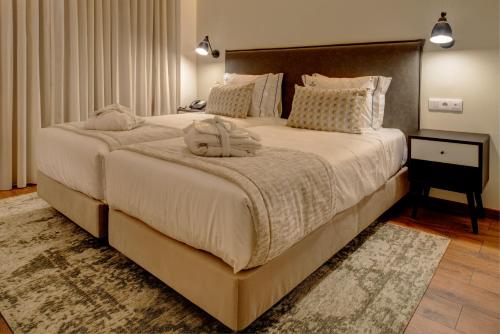 里斯本VIP Executive Picoas Hotel的一间卧室配有一张大床和床头板