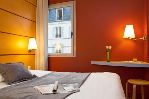 巴黎贝朗布阿城市酒店的酒店客房设有一张带窗户的床。