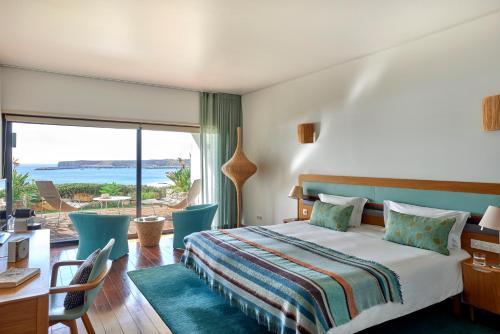 萨格里什萨格雷斯海滩马丁哈尔家庭度假酒店的一间卧室配有一张床,享有海景