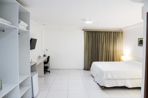 因佩拉特里斯Imperial Hotel的配有一张床和一张书桌的酒店客房