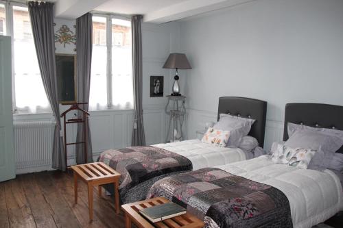 阿布维尔Les Capucines的一间卧室配有两张床和一张桌子