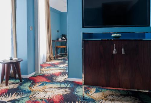 巴黎埃菲尔布洛梅特酒店的带电视的客厅和地毯地板