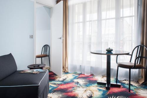 巴黎埃菲尔布洛梅特酒店的客厅配有桌椅和窗户。