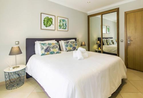 卢斯Cantinho da Praia的卧室配有一张白色大床和镜子