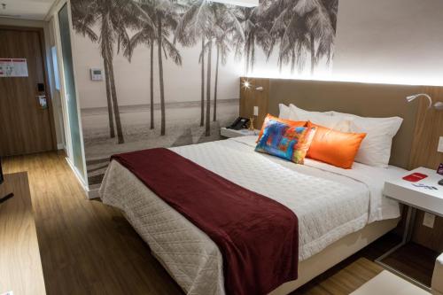 埃斯特城Rio Hotel by Bourbon Ciudad Del Este的卧室配有一张墙上棕榈树床。