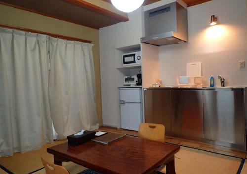 野沢Address Nozawa Japanese Room / Vacation STAY 22751的厨房配有木桌和冰箱。