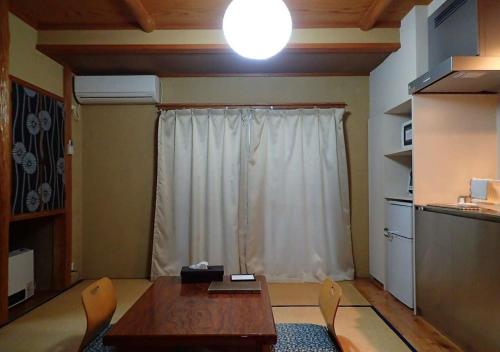 野沢Address Nozawa Japanese Room / Vacation STAY 22751的客房设有桌椅和窗户。