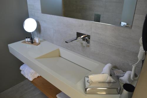 艾拉方索斯Double Bay Beach Hotel的一间带水槽和镜子的浴室