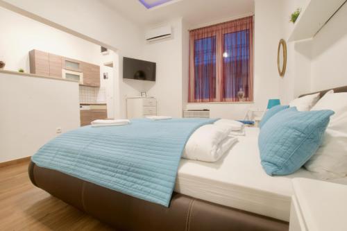 布达佩斯Standard Apartment by Hi5 -Baross Square的一间卧室配有一张带蓝白色枕头的大床