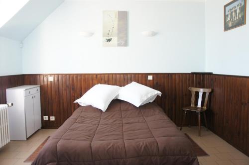 Germigny-des-PrésHôtel de la Place的一间卧室设有一张床和木墙