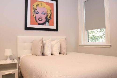 布鲁克林A Stylish Stay w/ a Queen Bed, Heated Floors.. #15的卧室配有一张白色床,墙上挂有绘画作品