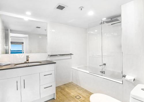 黄金海岸塔利斯曼公寓的带淋浴和盥洗盆的白色浴室