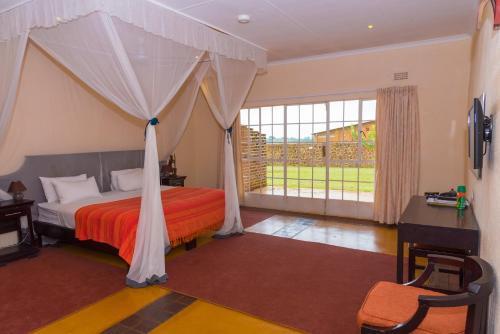 布兰太尔Game Haven Lodge的一间卧室配有一张带天蓬的床