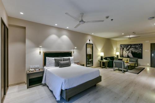 舍地Sun-n-Sand Suites, Shirdi的一间卧室设有一张床和一间客厅。