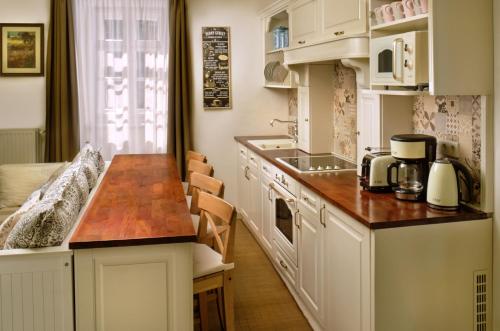 埃格尔Melody Apartman的厨房配有白色橱柜和木制台面
