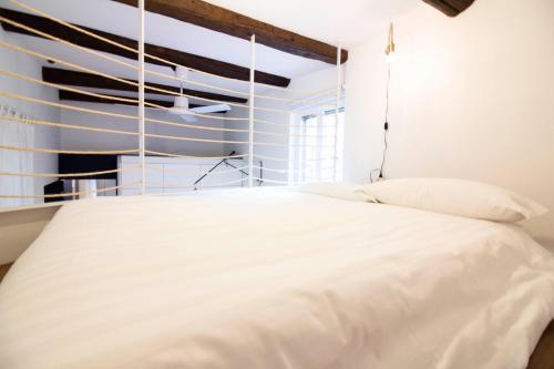 米兰Sant'Andrea cozy apartment的卧室配有白色的床和窗户。