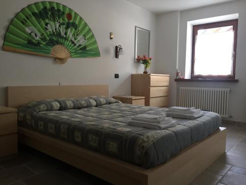 科马诺泰梅Casa Luigina的一间卧室配有一张挂着绿色画作的床铺。