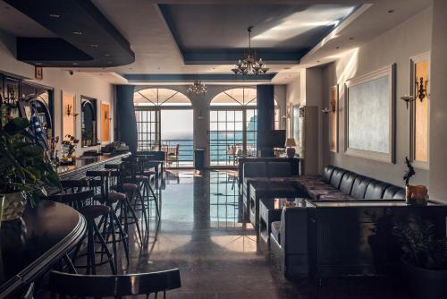 埃尔莫奈斯Hotel Elena Ermones的餐厅内带黑色皮革椅子和桌子的酒吧