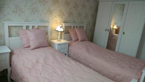 柏林Romantic Style Apartment Berlin Alexanderplatz的卧室内的两张床,配有粉红色的被子