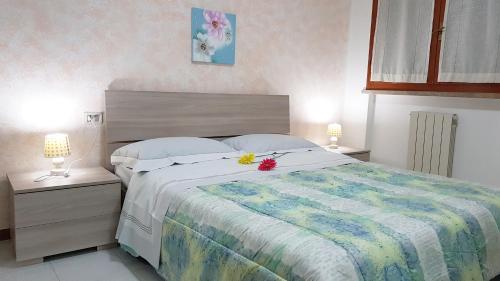 比萨Casa Excalibur的一间卧室,配有一张带鲜花的床
