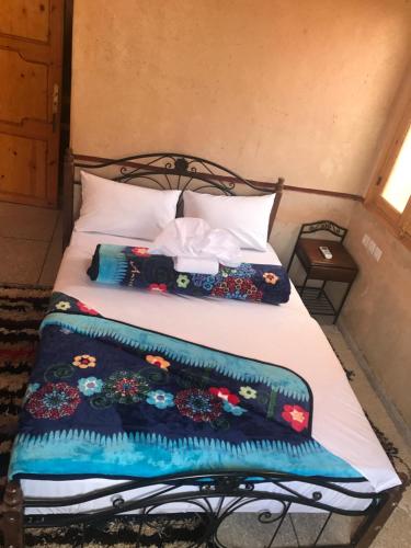 布马伦Auberge Restaurant Zahra的床上有两张枕头,有毯子