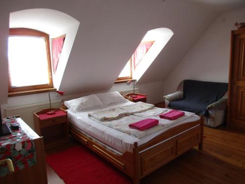 埃格尔Királyszéke Apartman的一间卧室配有床、两扇窗户和一把椅子
