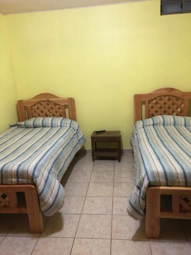 安托法加斯塔Casa Alejandra的铺有瓷砖地板的客房内的两张床