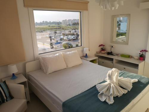 拉纳卡Bettys 1br seafront apt的一间卧室设有一张大床和大窗户
