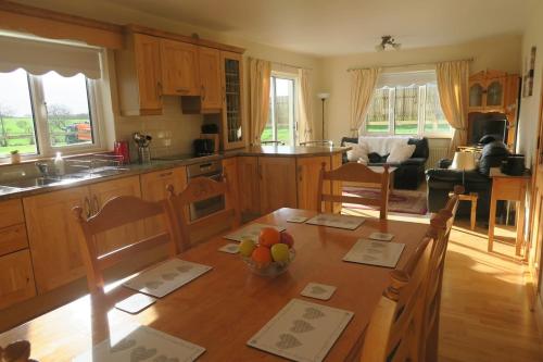 梅奥INGLEWOOD - Ballina - Crossmolina - County Mayo - Sleeps 8 - Sister property to Thistledown的厨房配有一张桌子,上面放着一碗水果