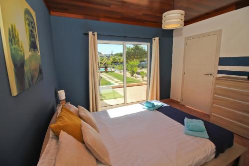 拉戈斯Quinta Gomes的一间卧室设有一张大床和一个大窗户