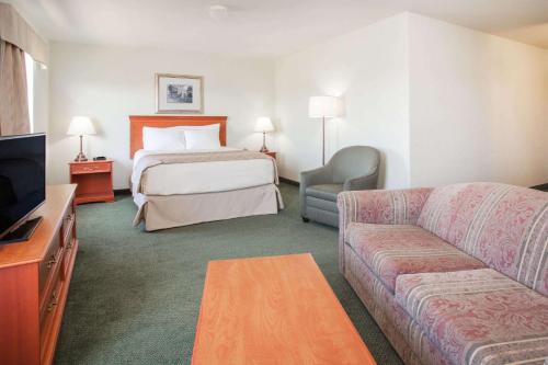 Swan River天鹅谷速8汽车旅馆的酒店客房,配有床和沙发