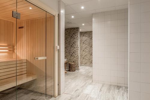 尼雪平Blommenhof Hotel的一间带步入式淋浴间和玻璃门的浴室