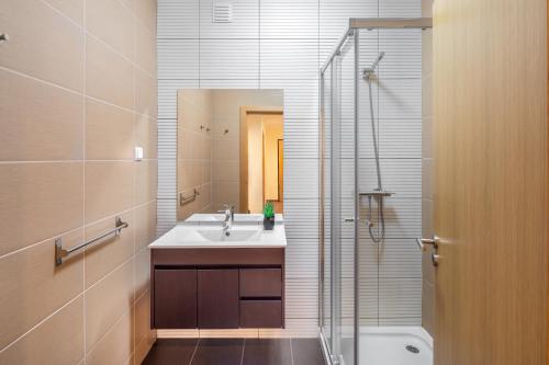 阿尔布费拉Marina Luxury Residence - Albufeira的一间带水槽、淋浴和卫生间的浴室