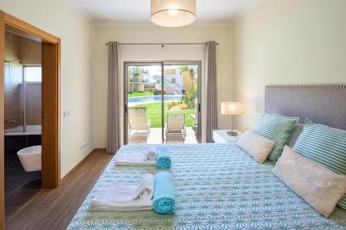 阿尔布费拉Marina Luxury Residence - Albufeira的一间卧室配有一张大床和毛巾