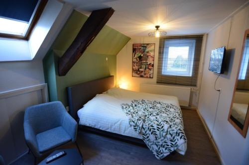 罗赫尔德布克拉尔酒店的一间小卧室,配有一张床和一张蓝色椅子