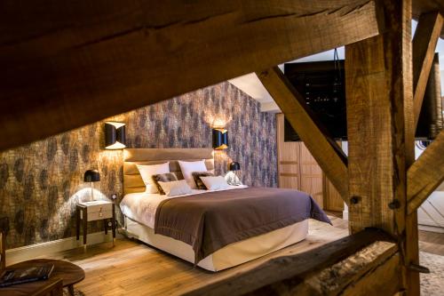 卡斯泰勒雅卢Hotel Clos Castel的一间卧室设有一张大床和木墙
