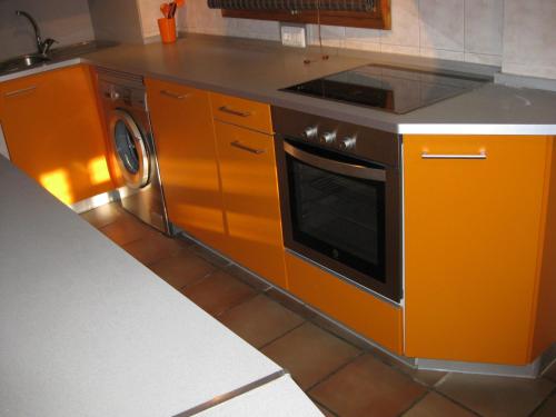 赫亚德亚尔瓦拉辛Casa Artigot的橙色的厨房配有炉灶和洗碗机
