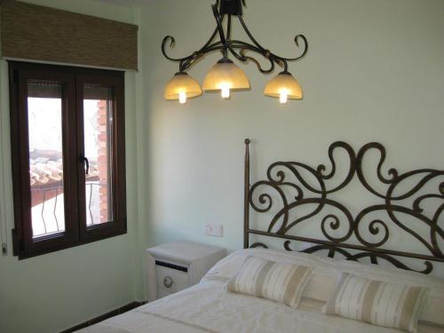 赫亚德亚尔瓦拉辛Casa Artigot的一间卧室配有一张床和一个吊灯