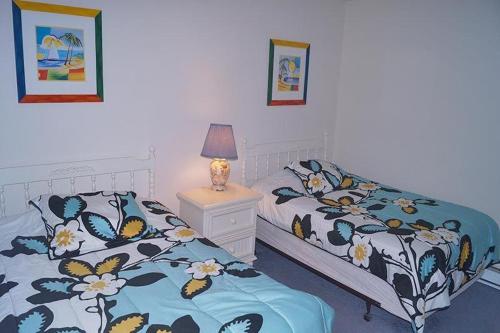 大洋城高点南3楼公寓的一间卧室配有两张床和床头灯。