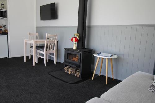 斯特拉特福德Brecon Pond Bed & Breakfast的客厅配有炉灶和桌椅