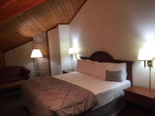墨西哥Amerihost Inn & Suites - Mexico的酒店客房,配有一张床和两盏灯